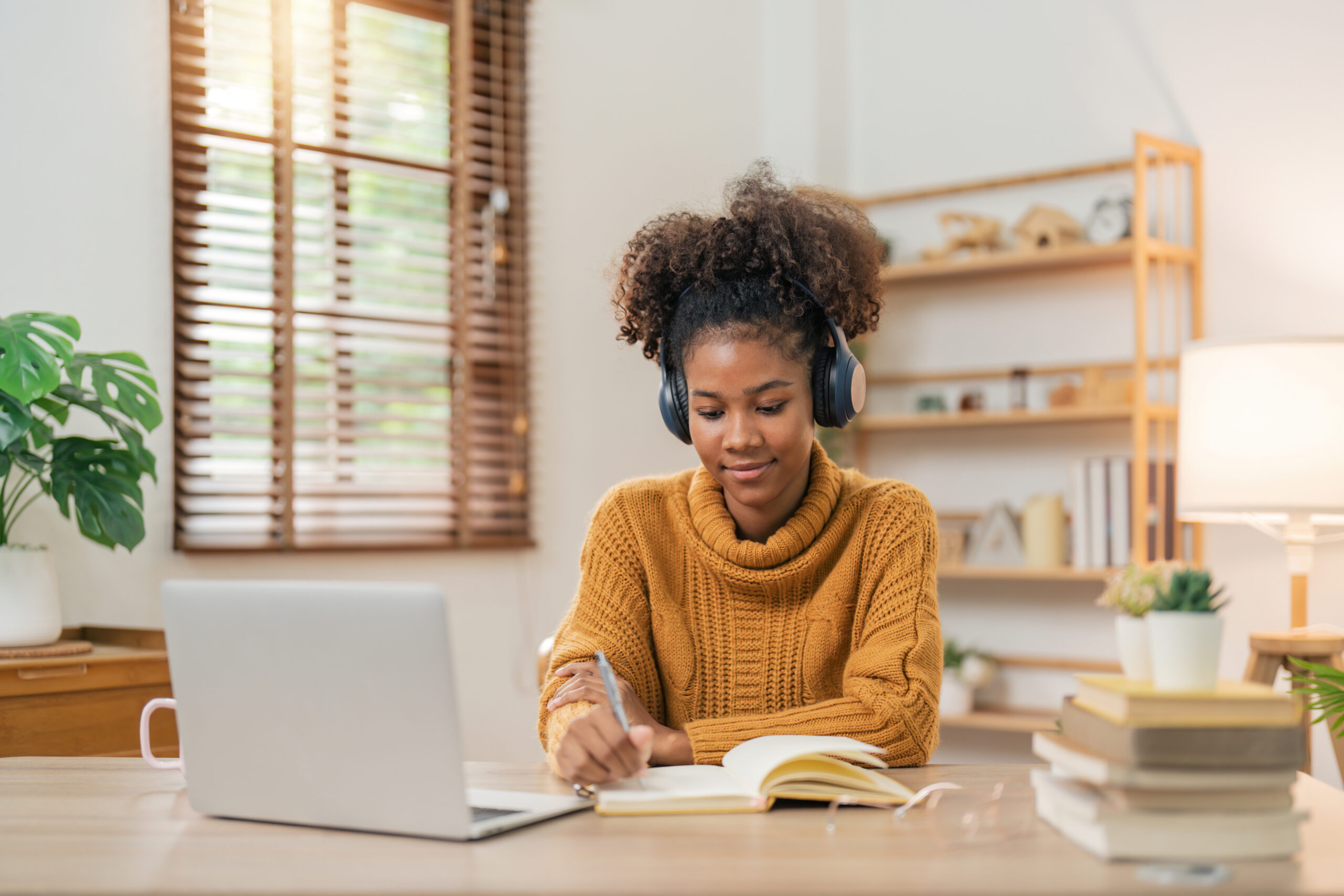 Professional using a laptop while working and taking notes